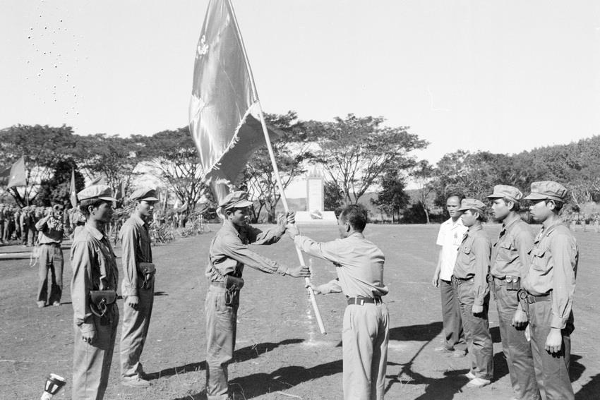 柬埔寨救国民族团结阵线主席（右）向柬埔寨革命武装力量授予国旗。图自越通社